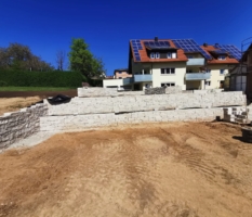 Erdarbeiten mit Natursteinmauer