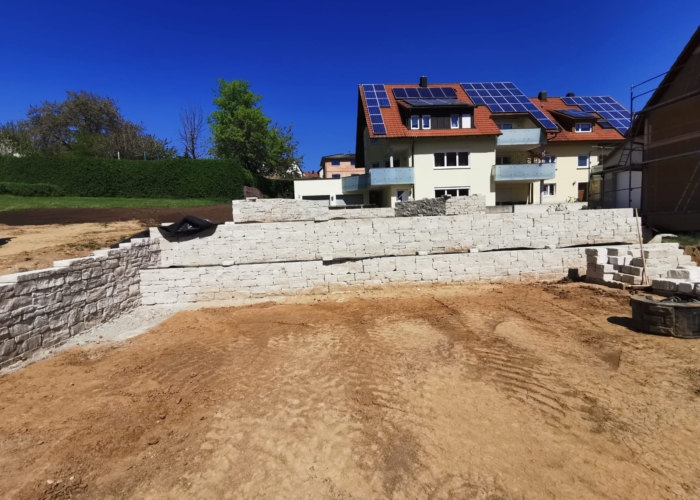 Erdarbeiten mit Natursteinmauer